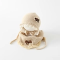 Close-up of baby winter set showing warm knitted texture with lace trim and fabric flowers - Beige