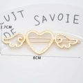 Golden heart wing hair clip with brushed metal texture shown in a white ceramic dish - Angel Wings Gold