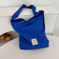 Detail van de Klein blauwe gewatteerde schoudertas met verticale plooien en wit label - Blauw