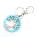 Handmade tree of life keychain with blue suede cord and turquoise stones on white background - Turquoise