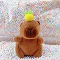 Cute Capybara plush keychain with a yellow pineapple hat on a colorful bubble background - Dark Brown Pineapple + Bead Chain