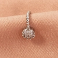 Detailed view of silver flower nose stud featuring sparkling crystals on pink fabric - Silver