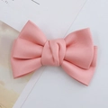 Close-up of pink faux leather bow accessory with realistic texture and knotted center - Pink