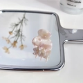 Mini acetate hair claw in light pink marble texture displayed on a mirror surface - Floral Pink