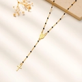 Detalle del collar rosario chapado en oro de 18K con cuentas negras y una cruz - Negro