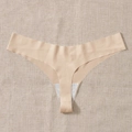 Seamless nude thong for women, high elasticity fitness underwear on beige linen background - S / Nude