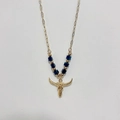 Macro detail of golden bull head pendant and blue beads on bohemian steel necklace - Bull Skull - Black Beads