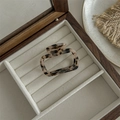Detail of a square leopard print hair claw clip on a beige velvet jewelry box - Gold Label Small Hollow Square