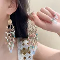 Dettaglio di orecchini a nappa dorati con perline multicolori e pendenti a goccia - Stile Nappa in Perle Vuote Oro Bohémien