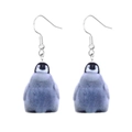 Macro detail of cute acrylic penguin earrings featuring high-gloss finish and silver hooks - Penguin