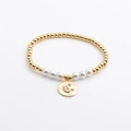Goldenes Perlenarmband mit weißen Perlen und einem himmlischen Mond- und Sternanhänger - Gold Mond & Stern
