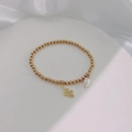 Close-up of golden beaded stretch bracelet with snake charm and baroque pearl detail - Gold-Smooth Snake