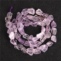Natural light purple amethyst raw stone beads arranged in a spiral on black background - 7-11mm Freeform Stone