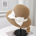 Detail of elegant straw sun hat with white bow and UV protection tag on a stand - Camel + White Bow