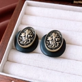 Nahaufnahme von Vintage-Ohrsteckern in Schwarz-Gold-Optik in einer weißen Samtbox - Goldrand Porträt Relief / Schwarz