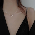 Élégant collier argenté à deux cœurs entrelacés porté par un mannequin au style chic - Argenté