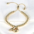 Close-up of golden beaded bracelet featuring a sparkling zircon initial P pendant - Letter P
