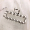 Close-up of a silver rectangular hollow metal hair claw clip on white satin background - Silver-Rectangular