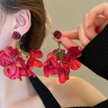 Close-up of fabric red rose tassel earring with green beaded stems on a model - 79# Silver Pin-Rose Tassel / Red