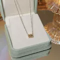 Elegant gold titanium necklace with a geometric cylinder pendant on a jewelry display - X048 Titanium Steel Color Retention
