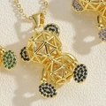 Gros plan du pendentif ours doré avec motif ajouré géométrique et zircons colorés - Or / Zircone Bleu Royal