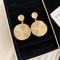 Detailaufnahme goldener Vintage-Ohrringe mit Spiralstruktur auf schwarzem Samt - Große Scheibe mit Spiraltextur / Gold