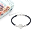 Dettaglio del ciondolo Mom a cuore su bracciale intrecciato nero con chiusura argento - Nero