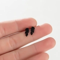 Macro shot of black feather stud earrings showing realistic texture and finish - Leaf / Black