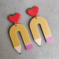 Close-up of creative pencil-shaped wooden earrings with red heart studs for teachers - Heart Decor Yellow Pencil