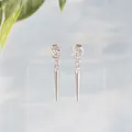 Dettaglio macro di orecchini a punta in argento 925 con zirconi su espositore - Stile Bottone Pendente / Argento