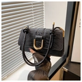 Detail of black faux crocodile skin handbag with elegant gold U-shaped metal buckle closure - Black
