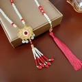 Dettaglio della collana con lucchetto Fenice, nappe di seta rossa e ciondolo dorato - Collana Lunga con Nappa Ruyi Lock / Oro Rosso con Perle Bianche