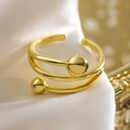 Bague spirale multicouche plaquée or 18 carats avec boules dorées sur satin blanc soyeux - Style Spirale Double Boule à Trois Couches (14164)