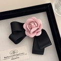 Detail van roze stoffen camelia en zwarte satijnen strik haarclip met luxe textuur - Roze Camelia Strik Haarklem