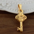 Vue macro d'un pendentif clé en acier inoxydable plaqué or 24K avec détails trèfle - Clé / Or