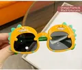 Kids orange dinosaur sunglasses with dark grey lenses and green back fin design - Orange & Yellow