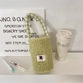 Close-up of green fleece cup bag with checkered handle and cute cat patch detail - Avocado Green