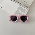 Top view of pink silicone children's polarized sunglasses on a white spiral notebook - Pink
