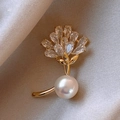 Elegant gold butterfly brooch with shimmering rhinestones and a pearl on beige satin - Gold