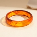 Minimalist amber resin round geometric bangle featuring warm caramel tones and sand patterns - Brown