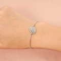 Pulsera minimalista de acero inoxidable plateado con hoja sobre fondo de seda suave - Color Acero