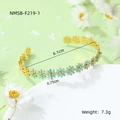 Detail shot of a gold-plated daisy cuff bracelet featuring blue enamel flowers and size marks - Light Blue Bracelet