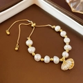 Detail of freshwater pearl bracelet featuring a gold shell charm with sparkling crystals - Shell Pendant Style / Gold Pearl Shell