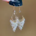 French palace style teardrop earrings with gold crystal tassels on black card - Transparent White Bead Style / Ear Hooks - Gold - White