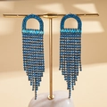 Detailansicht der Quastenohrringe mit blauen Zirkonia am goldenen Schmuckständer - Blau (Silberner Ohrringstecker)