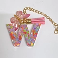 Letter W resin keychain with pink tassel, butterfly charm, and colorful heart sequins - Letter W