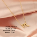 Golden Scorpio constellation necklace with letter m pendant on pink silk background - Scorpio