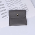 Gray lychee grain leather jewelry pouch with gold round metal snap on an open book - PU Litchi Texture Leather (Dark Grey) / 10x10cm