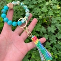 Nahaufnahme von Silikonperlen-Armband-Schlüsselanhänger mit bunter Quaste und Goldring - Bunte Quaste Blaue Perlen mit Marmormuster (Stil 10)