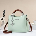 Borsa verde menta con manici in pelle marrone e ciondolo a forma di stella in metallo argentato - L25 P12 A20 / Verde matcha